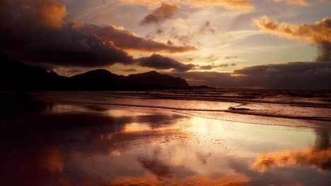 Incredible-golden-reflections-of-the-beautiful-sunset-on-the-surfer-beach-of-Flakstad-Lofoten-Islands,-Norway