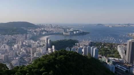 Breite-Luftaufnahmen,-Die-über-Den-Bäumen-Des-Berggipfels-Rotieren,-Mit-Der-Botafogo-Bucht-Im-Hintergrund