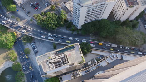 Top-down,-aerial-footage-flying-over-in-apartment-building,-revealing-early-morning-traffic-in-Rio-de-Janeiro-Brazil