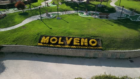 Aufsteigende-Antenne-Blickt-Auf-Den-In-Blumen-Geschriebenen-Namen-Der-Stadt,-Molveno,-Italien