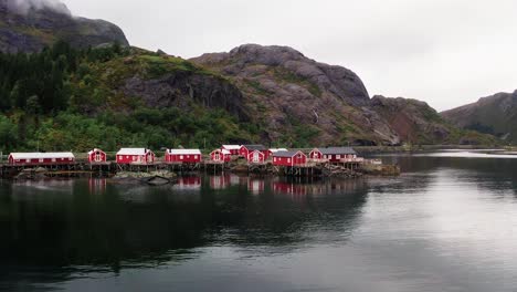 Aerial-low-flying-fast-footage-of-the-red-rorbu-houses-in-the-beautiful-fisher-village-of-Å-in-the-Lofoten-Islands,-Norway