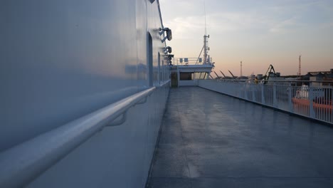 On-the-open-deck-of-a-ferry,-where-there-are-no-people,-there-is-a-captain's-bridge-or-wheelhouse-at-the-front-of-the-deck