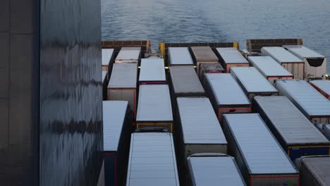 The-semi-trailers,-together-with-the-truks,-are-parked-on-the-open-deck-of-the-ferry-when-it-is-currently-sailing-in-the-sea