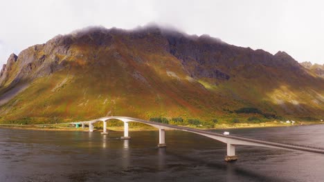 Luftaufnahme-Eines-Weißen-Wohnmobils,-Das-Eine-Wunderschöne-Brücke-In-Den-Fjorden-Der-Lofoten-Inseln,-Norwegen,-überquert