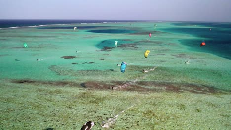 Farbenfrohes-Kitesurfen-Auf-Türkisfarbenem-Wasser-Bei-Los-Roques,-Lebendige-Erholung-Im-Freien,-Luftaufnahme