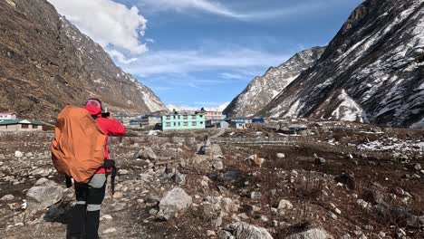 Hiker-in-red-jacket-taking-a-photo-on-arrival-in-Langtang-village