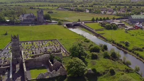 Klosterruinen-Und-Schloss-Von-Claregalway-An-Einem-Sonnigen,-Lebhaften-Tag,-Luftaufnahme-Vom-Fluss-Clare