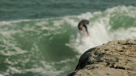 A-cinematic-slow-motion-shot-of-a-surfer-riding-a-wave-in-Santa-Cruz,-CA-at-Steamer-Lane