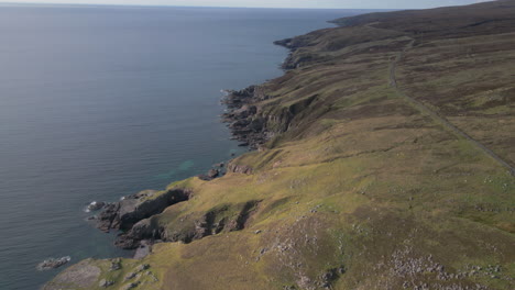 Coastal-cliffs-and-winding-road-along-the-rugged-shoreline-of-Melvaig,-Scotland