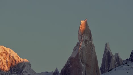 The-iconic-Cerro-Torre-peak-glow-with-the-warm-light-of-sunrise-against-a-clear-sky-in-Patagonia