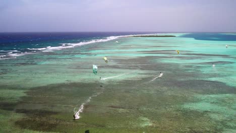 Kite-surfers-on-clear-turquoise-waters-at-los-roques-during-the-day,-aerial-view