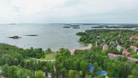 Drone-flying-around-the-Kasinonranta-beach,-summer-day-in-Lauttasaari,-Finland
