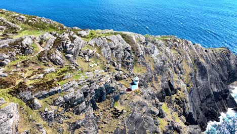 Ireland-Epic-locations-drone-circling-sheep’s-Head-Lighthouse-on-rocky-outcrop-in-Bantry-Bay-in-West-Cork-on-the-Wild-Atlantic-Way-tourist-destination-and-magnificent-wild-location
