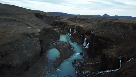 Atemberaubende-Landschaft-Islands,-Drohnen-Luftaufnahme-Von-Wasserfällen,-Vulkanischen-Klippen-Und-Canyons-Mit-Kaltem-Blauem-Gletscherflusswasser