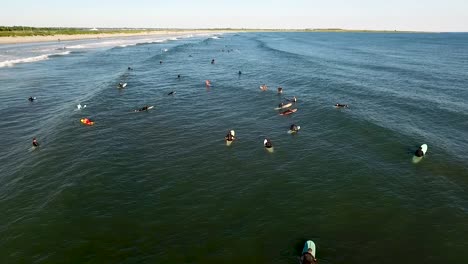 Aerial-footage-of-many-surfers-riding-the-waves-along-the-coast-of-Rhode-Island