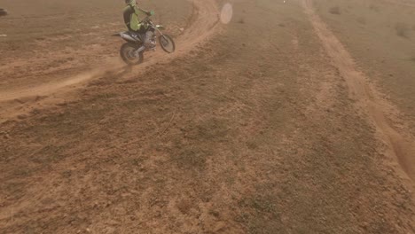 Exciting-dramatic-FPV-drone-follows-motocross-racer-on-dirt-track