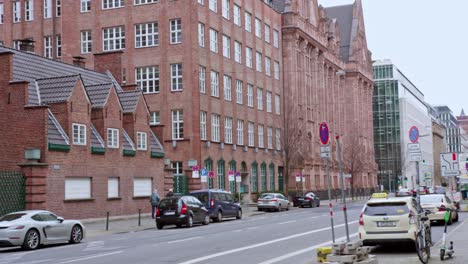 Hermosa-Casa-Antigua-En-El-Casco-Antiguo-De-Dusseldorf,-Edificio-Marrón-Con-Un-Coche-Pasando-En-Movimiento-Panorámico-En-Cámara-Lenta