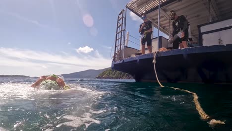 A-static-shot-of-a-man-steps-off-boat-to-dive-in-the-ocean
