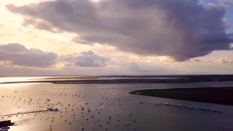 Aerial-of-Essex-Coast-West-Mersea-Harbour-in-Early-evening-light,-Drone-Tracking-Wide-shot