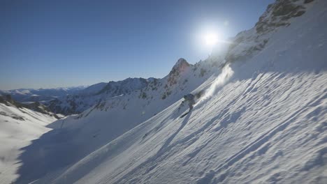 Ein-Fantastischer-Skifahrer,-Der-In-Zeitlupe-Einen-Steilen-Pulverschneehang-Hinunterfährt,-Mit-Einem-Unglaublichen-Winterberghintergrund-Und-Blauem-Himmel