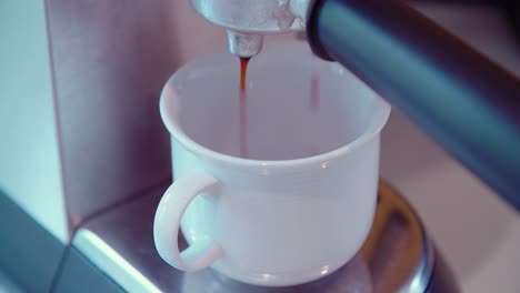Coffeecup-under-espresso-maker-starting-pouring