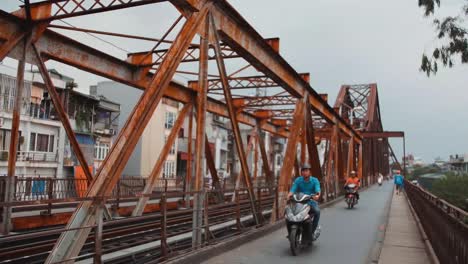 Puente-Long-Biên---Motocicletas-Que-Viajan-A-Través-Del-Histórico-Puente-Voladizo-En-Cau-Long-Bien-En-La-Ciudad-De-Hanoi,-Vietnam