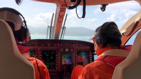 Helicopter-cockpit-with-two-pilot-while-on-air-approaching-airport-with-beautiful-mountain-view