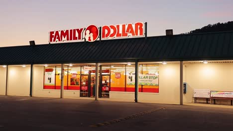 Small-Family-Dollar-Store-Front-At-Night-With-Covered-Porch-With-Lights-And-Lighted-Sign-On-Top-Of-Store-Parallax-Cinematic-HD