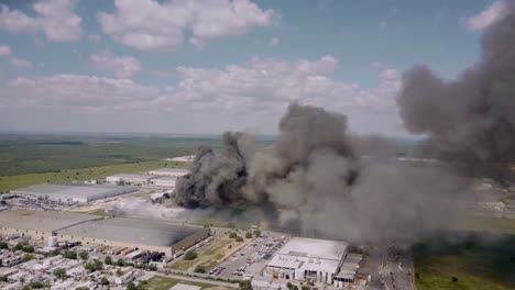 Aerial---textile-factory-fire-in-Reynosa,-Tamaulipas,-Mexico,-wide-circling-shot