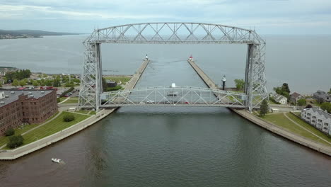 Drone-shot-of-Duluth-Lift-Bridge-with-traffic-crossing-and-small-boat