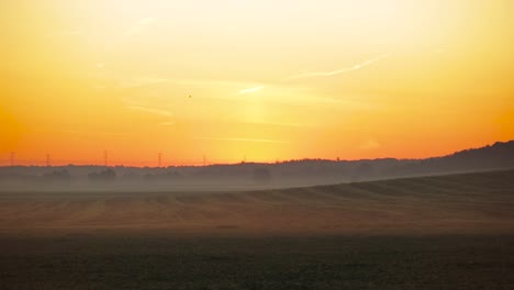 Wunderschöner-Orangefarbener-Himmel-über-Der-Atemberaubenden-Nebligen-Landschaft-In-Polen---Weitwinkelaufnahme