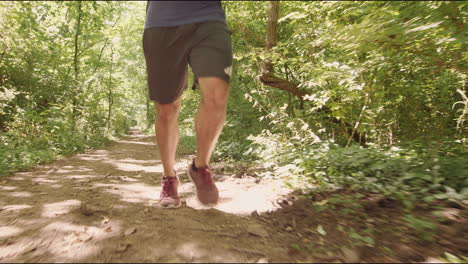 Young-man-running-through-forest-trail