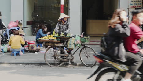 Hombre-Vietnamita-Vende-Fruta-Desde-Su-Bicicleta-En-Las-Calles-De-Hanoi,-Cámara-Lenta