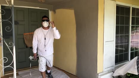 painter-using-airless-sprayer-to-paint-stucco-walls