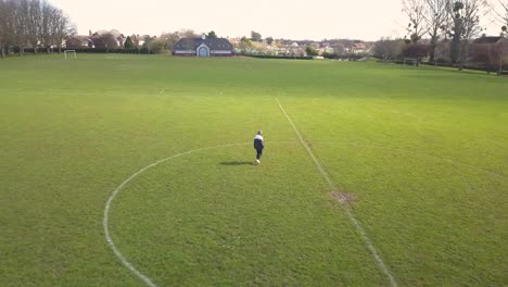Young-man-walking-around-in-a-empty-football-field