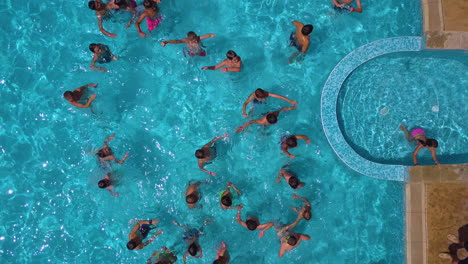 Vista-Superior-De-La-Toma-De-Drones-De-La-Piscina-En-El-Complejo-Hotelero-Con-Niños-Jugando