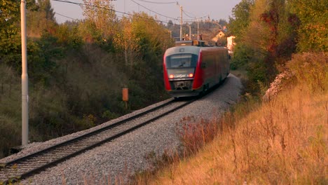 A-train-passes-by-a-curved-train-track-on-a-bright-autumn-fall-day