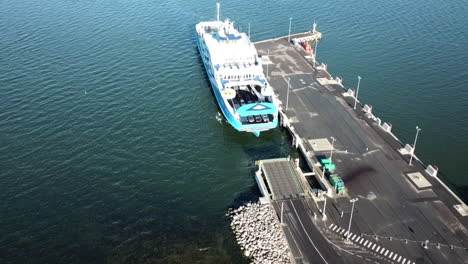 drone-descending-shot-of-ferry-approaching-the-port-landing-and-waiting-area-in-virtsu-harbour-estonia