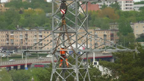 Climber-electrician-on-a-high-voltage-pole-in-town