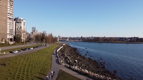 Hunderttausende-Menschen-Drängen-Sich-Auf-Der-Ufermauer,-Ignorieren-Die-Abstandsregeln-Und-Laufen-Unwissentlich-Dicht-Aneinander-Und-An-Den-Passanten-Auf-Der-Strandpromenade-Von-English-Bay-Vorbei