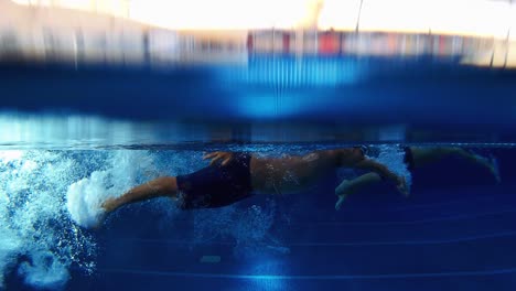 Kleine-Kinder,-Die-An-Einem-Schwimmwettkampf-Teilnehmen,-Tauchen-In-Den-Pool-Ein