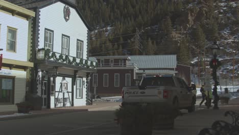 Static-view-of-white-County-public-hall-across-the-road-with-locals-passing-by-in-Colorado,-USA-with-mountain-range-in-the-background-at-daytime