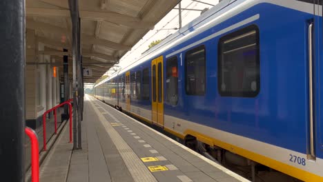 Un-Tren-Eléctrico-En-Holanda-Sale-De-Un-Andén-En-Un-Pequeño-Pueblo.