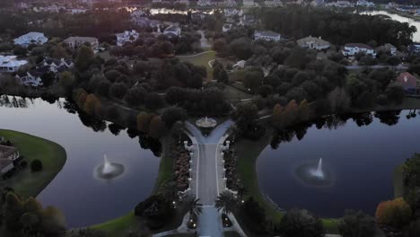 Luftaufnahme-Einer-Brücke,-Die-Bei-Sonnenuntergang-In-Ein-Abgeschiedenes-Luxusviertel-Im-Norden-Floridas-Führt,-Das-Von-Dichtem,-Unbebautem-Wald-Umgeben-Ist