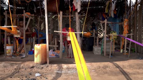 Una-Cabaña-De-Tejido-Al-Aire-Libre-Protegida-Del-Sol-Por-Bambú-Y-Hojas-De-Palma-Es-Donde-Los-Tejedores-Fabrican-La-Colorida-Tela-Kente-Para-La-Ropa-Tradicional-Africana