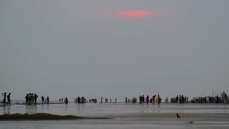 Turistas-En-La-Orilla-De-Una-Playa-Tranquila-Al-Atardecer-En-Bangladesh,-Asia