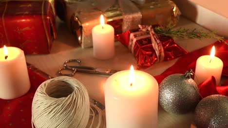 Weihnachtshintergrund-Mit-Kerzen,-Verpackten-Geschenken-Und-Verpackungsmaterial