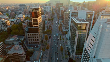 Drone-flying-fast-over-Apoquindo-Avenue-Skyscrapers-at-sunset,-descending-shot