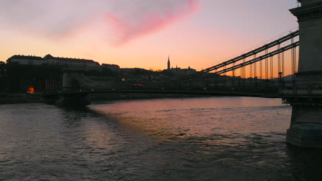 Luftaufnahme-Des-Sonnenuntergangs-über-Der-Kettenbrücke-Mit-Abendlichem-Verkehr-In-Budapest