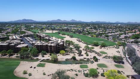 Aerial-pull-back-to-reveal-Westin-Kierland-Resort-surrounding-gold-course-with-activities-on-the-fairways,-tees,-and-greens,-Scottsdale,-Arizona